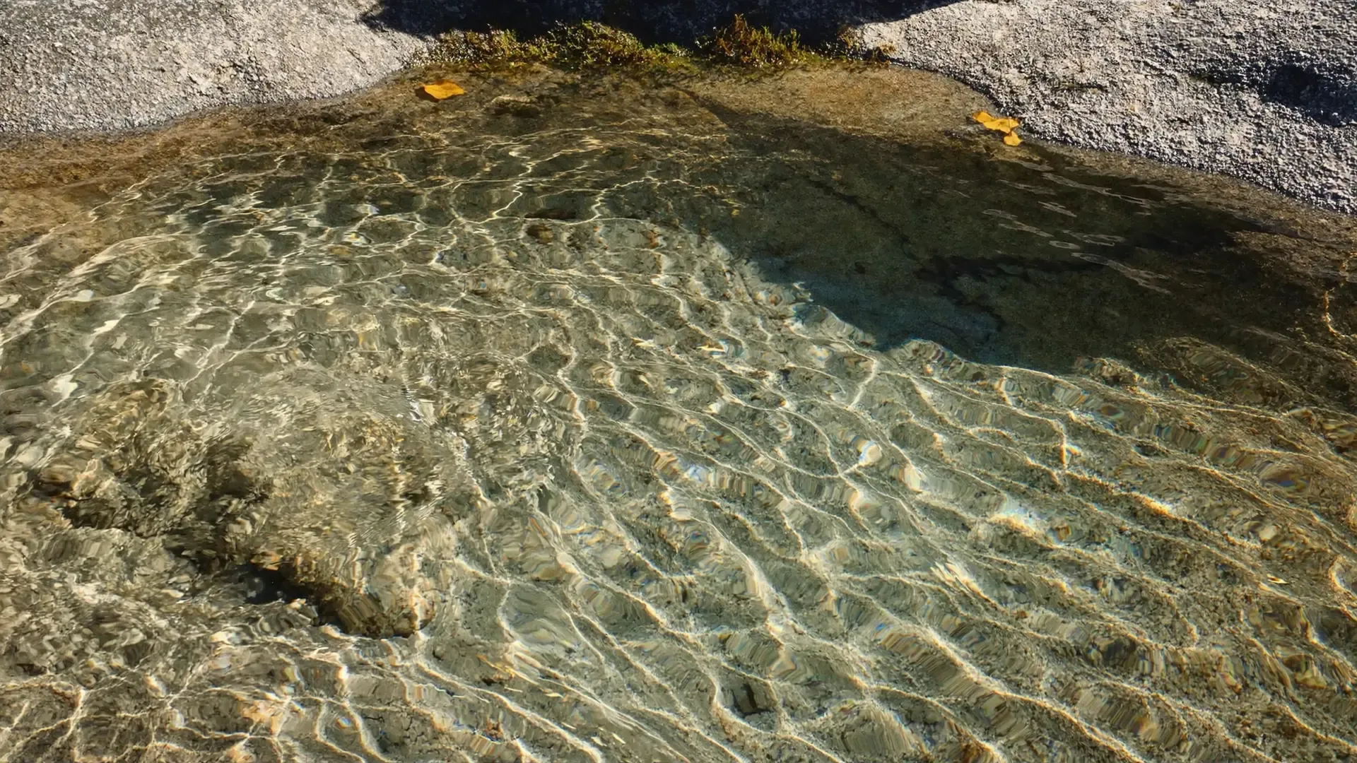 Clear water pooling in a granite basin, the bedrock that shapes Maine well water
